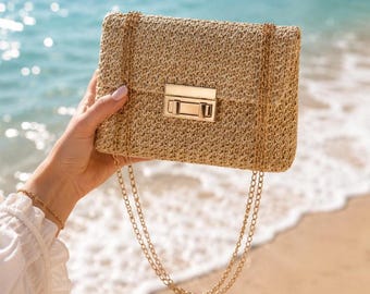 A stylish, handcrafted handbag, adorned with a gold-tone chain, perfect for a sophisticated summer evening look.