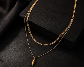 A minimalist, multi-layered gold necklace for men, a modern piece of jewelry inspired by street style.