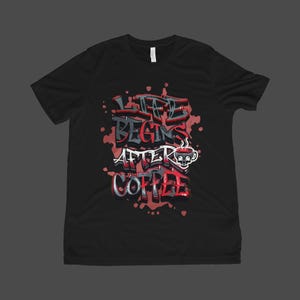 May include: Black t-shirt with the phrase "LIFE BEGINS AFTER COFFEE" in a graffiti-style design. The design includes a coffee cup with a skull face and red and gray accents. The shirt is a crew neck.