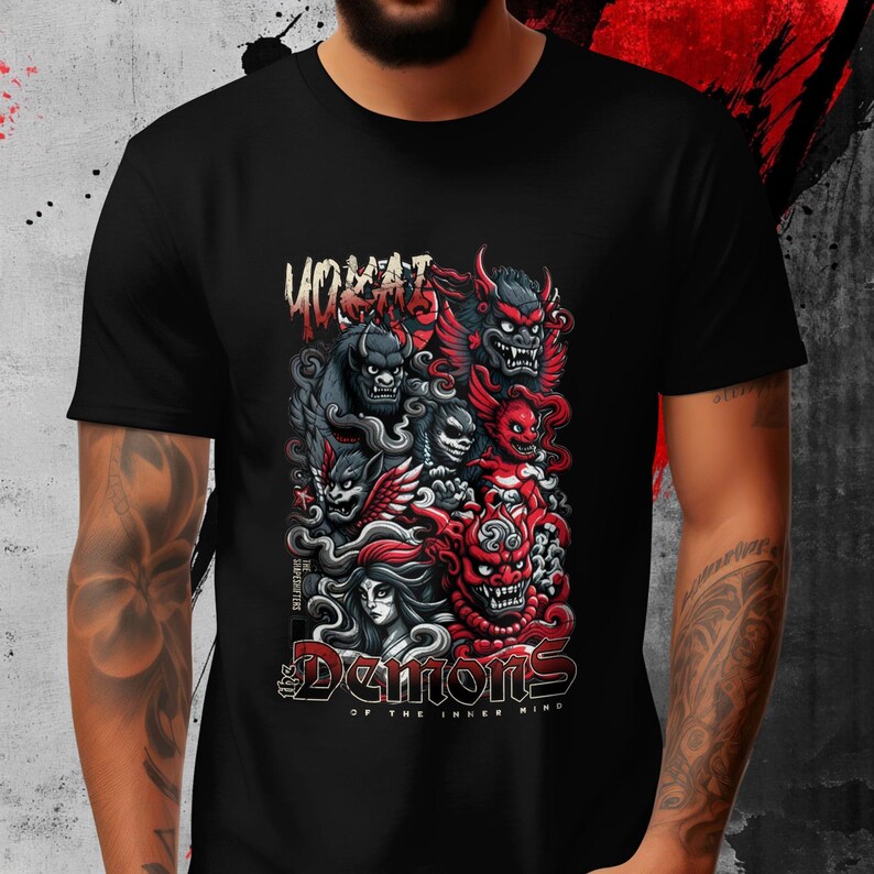 May include: Black t-shirt featuring a detailed graphic of stylized demons in red, gray, and black. The design includes the text "YOKAI" above and "The Demons of the Inner Mind" below the central illustration.