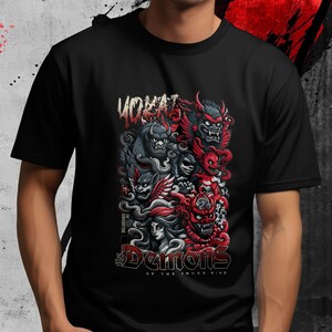 May include: Black t-shirt featuring a colorful graphic of stylized demons in red, gray, and black. The design includes the text "YOKAI" at the top and "Demons of the Inner Mind" at the bottom.