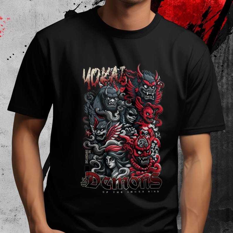 May include: Black t-shirt featuring a colorful graphic of stylized demons in red, gray, and black. The design includes the text "YOKAI" at the top and "Demons of the Inner Mind" at the bottom.