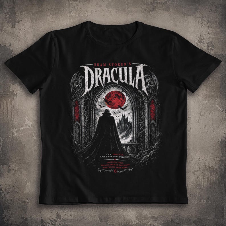 May include: A black t-shirt featuring a graphic print of Bram Stoker's Dracula. The design shows a cloaked figure standing before a gothic archway with a red moon, bats, and a castle. Text includes "Bram Stoker's Dracula" and "I am Dracula, and I bid you welcome."