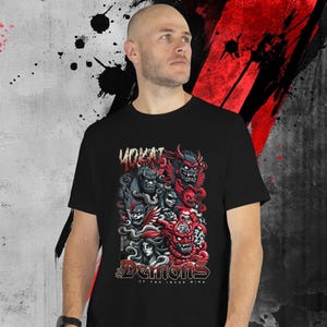 May include: Black t-shirt featuring a vibrant graphic of stylized demons in red, gray, and black. The design includes the word "YOKAI" at the top and "Demons of the Inner Mind" at the bottom. The shirt is worn by a person.
