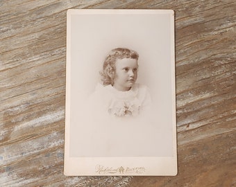 Vintage photo of a little girl, sepia tone on cardboard