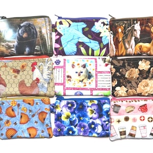 Puede incluir: Nueve pequeñas bolsas con cremallera con varios diseños, incluyendo un oso, un pájaro azul, caballos, gallinas, un gato, estampados florales, abejas, flores moradas y tazas de café. Cada bolsa tiene un pequeño anillo de metal.