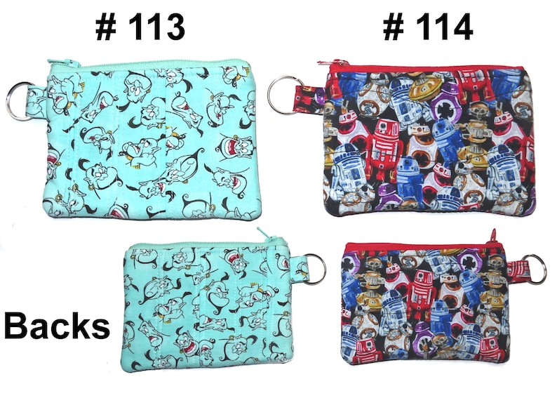 May include: Small zippered coin purses with key rings. One purse is light blue with a cartoon character print. The other purse has a red zipper and features a print of various robot characters. The purses are labeled #113 and #114.