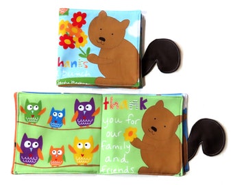 May include: A soft, colourful baby book with a brown bear and owls on the cover. The book has the text "Thank you for our family and friends." on the cover.