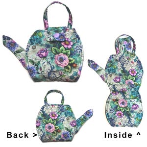 May include: A floral-patterned teapot-shaped bag with a handle, spout, and a small pocket. The bag features a teal background with pink, purple, and blue flowers. The text "Back >" and "Inside ^" are visible.