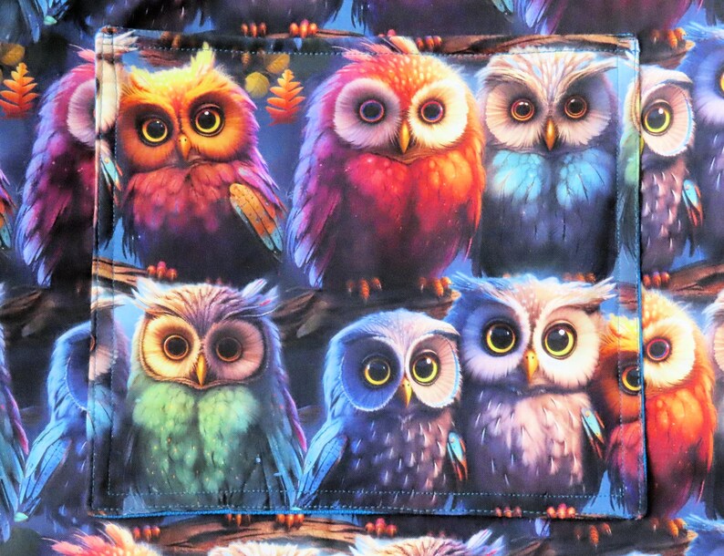 May include: A fabric panel featuring a repeating pattern of colorful owls. The owls have large, expressive eyes and are depicted in shades of red, orange, blue, and green against a dark blue background. The design is detailed and whimsical.