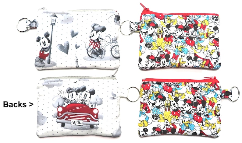 May include: Four small zippered coin purses. Two purses feature Mickey Mouse in Paris scenes, and two feature Mickey, Minnie, and Donald Duck. Each purse has a key ring attached.