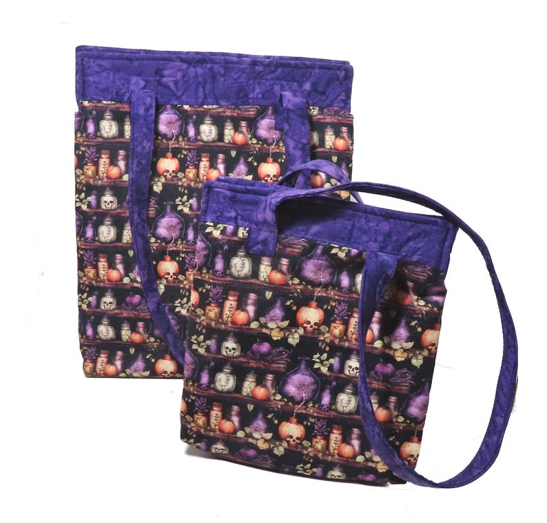 May include: Two quilted tote bags featuring a dark fabric pattern of shelves filled with various potion bottles, skulls, and small orange pumpkins. Each bag has a solid purple fabric trim along the top edge and matching purple fabric handles.