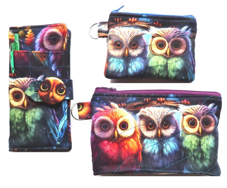 May include: A set of three owl-themed accessories: a wallet with a pen, a small coin purse, and a larger zippered pouch. The items feature a colorful owl design with vibrant blues, greens, and reds against a dark background.