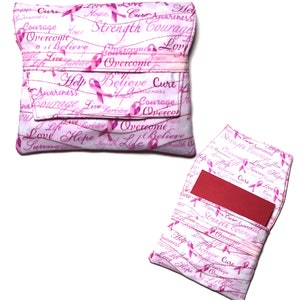 May include: Pink fabric wallet with a flap closure. The wallet is decorated with pink ribbons and the words "Love", "Hope", "Strength", "Courage", "Believe", "Cure", "Help", "Survive", "Overcome", and "Life".