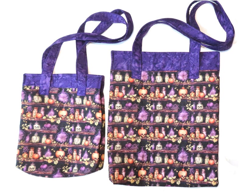 May include: Two fabric tote bags with purple handles and a top border. The main body features a repeating pattern of shelves holding various glass bottles, skulls, and orange pumpkins against a black background. The bags are rectangular in shape.