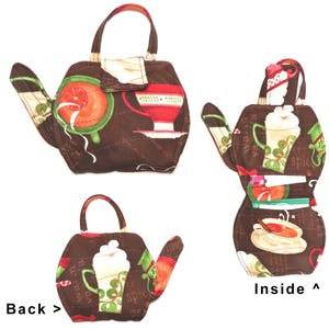 May include: Brown quilted teapot-shaped purse with a handle. The purse features a flap closure and is decorated with coffee and tea-themed patterns in red, green, and white. The inside of the purse has pockets for storage.