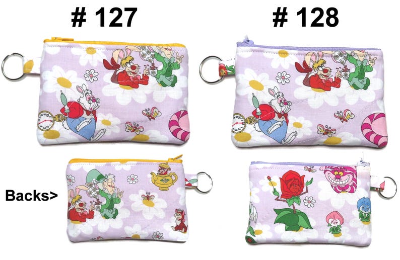 May include: Four small, rectangular coin purses with zipper closures and key rings. The purses feature an Alice in Wonderland theme with characters like the White Rabbit and Cheshire Cat on a light purple background with white daisies.