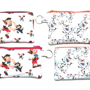 May include: Four small, rectangular zippered pouches. Two pouches feature a print of Pinocchio and Figaro the cat, with red zipper trim. The other two pouches have a print of Olaf from Frozen, with orange zipper trim. Each pouch has a silver key ring.