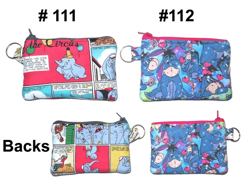 May include: Four small, rectangular coin purses with zippers and key rings. Two purses feature a Dumbo the Elephant comic strip design, and two feature Eeyore from Winnie the Pooh. The purses have a variety of colors, including red, blue, and pink.