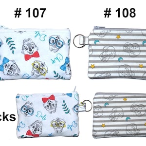 May include: Two small, rectangular coin purses with zippers and key rings. One is white with Chip and Dale cartoon characters and the text "Chip" and "Dale". The other is gray and white striped with cartoon character outlines, moons, and stars. The word "Backs" is printed on the bottom left.