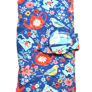 May include: A blue fabric case with a floral and bird pattern. The design includes red teapots, yellow birds, and various flowers. A round button closure secures the case.