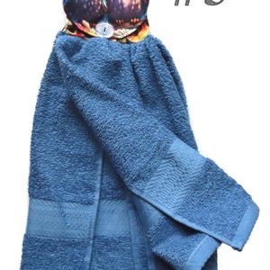 May include: Blue kitchen towel with an owl-themed top. The top features two owls with large yellow eyes. The towel is a solid blue color with a textured surface. The number "#5" is printed in the upper right corner.