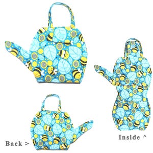 May include: A blue, bee-themed fabric watering can-shaped bag with a handle. The bag features a pattern of bees, sunflowers, and leaves. The inside of the bag is also visible, showing the same pattern. The text "Back >" and "Inside ^" are also visible.