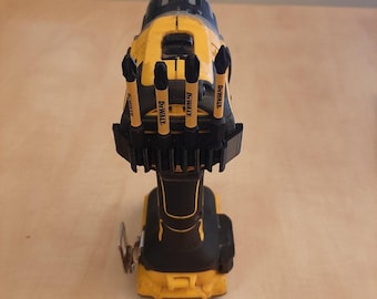 May include: A yellow and black cordless drill with a black and yellow bit holder. The bit holder has five drill bits with the word "DEWALT" printed on each bit.