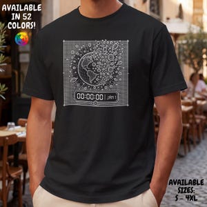 May include: A black short-sleeve t-shirt featuring a white graphic of a globe within a grid, surrounded by small geometric shapes and a digital clock display reading 00:00:00 JAN 1. The text AVAILABLE IN 52 COLORS and AVAILABLE SIZES S-4XL is visible.
