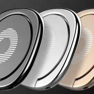 May include: Three phone ring holders in different colors: black, silver, and gold. Each holder has a raised ring with a textured design.