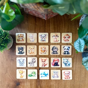 Può includere: Un set di 18 tessere di legno con illustrazioni di animali carini. Ogni tessera ha un animale diverso, tra cui una tigre, un koala, un panda, una zebra, una giraffa e molto altro. Le tessere sono perfette per una varietà di giochi e attività.