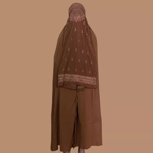 May include: A brown abaya with a matching headscarf. The headscarf has a decorative pattern with gold embroidery.