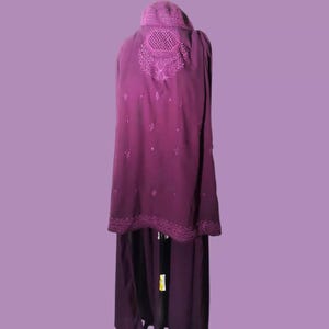 May include: A long, purple, embroidered shawl with a decorative design on the back. The shawl is made of a soft, flowing fabric and has a scalloped edge.