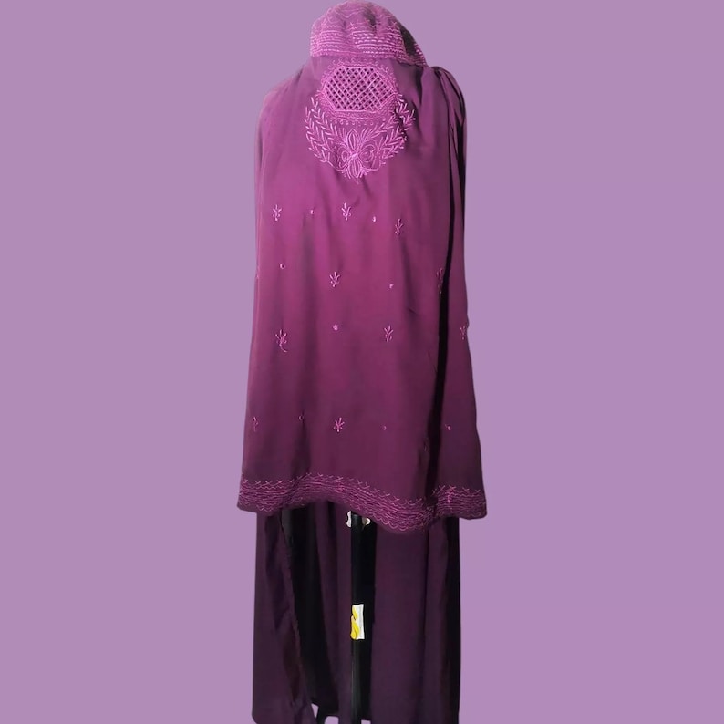 May include: A long, purple, embroidered shawl with a decorative design on the back. The shawl is made of a soft, flowing fabric and has a scalloped edge.