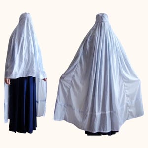 May include: A light blue, long, flowing garment with a gathered neckline and a wide, flowing skirt. The garment is made of a lightweight fabric and has a simple, elegant design.