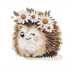 Puede incluir: Diseño bordado de un erizo marrón con una corona de flores de margarita blancas. El erizo está sonriendo y tiene un ojo guiñando.