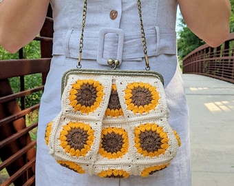 May include: A crocheted sunflower purse with a brown and yellow design. The purse has a clasp closure and a chain strap.
