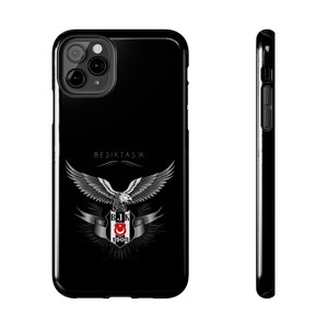 May include: Black phone case featuring the Besiktas JK logo. The logo includes a silver eagle with outstretched wings, a shield with a red crescent and star, and the text "BESIKTAS JK" and "1903".