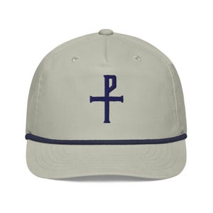 May include: A light grey baseball cap featuring a navy blue rope brim and a navy blue embroidered cross symbol. The cap has a curved peak and a button on top.