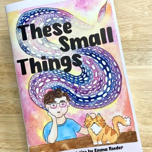 Puede incluir: Un fanzine titulado "These Small Things" con una ilustración en acuarela. La portada presenta una persona con gafas y un gato, con un diseño arremolinado azul y morado. El texto "A coming out zine by Emma Roeder" está en la parte inferior.