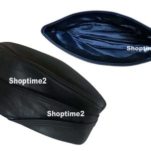 Può includere: Due cappelli neri in stile militare. Uno è mostrato di lato e l'altro dall'interno. I cappelli hanno una consistenza liscia, simile alla pelle. Il testo "Shoptime2" è stampato sui cappelli.