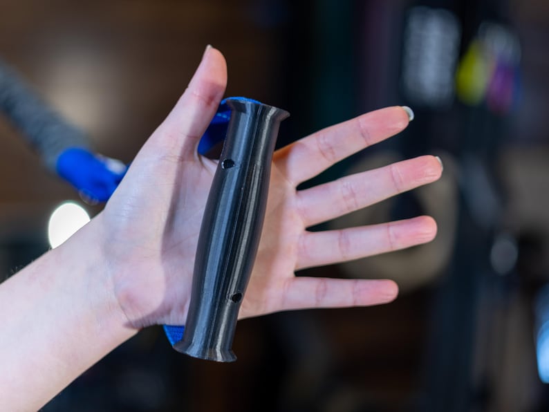 Pode incluir: Uma pega de exerc&iacute;cio preta e azul com uma pega texturizada. A pega tem um furo no lado.