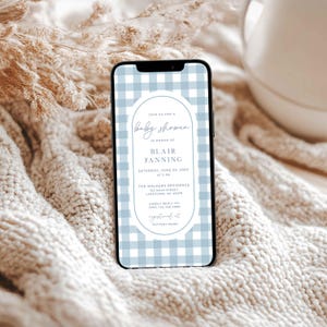 Może przedstawiać: Zaproszenie na baby shower na ekranie smartfona z wzorem w kratę w kolorze niebieskim i białym. Zaproszenie zawiera biały owal z niebieską obw&oacute;dką i tekst "Join us for a baby shower in honor of Blair Fanning, Saturday, June 22, 20xx at 3 pm, The Walkers Residence, 123 Main Street, Laketown, NC 45478, Kindly reply to 2015 123 456 7890, registered at Pottery Barn."