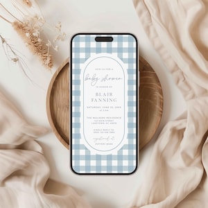 Może przedstawiać: Zaproszenie na baby shower na ekranie smartfona z wzorem w niebiesko-białą kratę. Tekst zaproszenia brzmi: "Dołącz do nas na baby shower z okazji narodzin Blair Fanning, sobota, 22 czerwca 20xx o 15:00, The Walkers Residence, 123 Main Street, Laketown, NC 48678, Prosimy o potwierdzenie udziału pod numerem 2855: 123 456 7890, zarejestrowane w Pottery Barn."