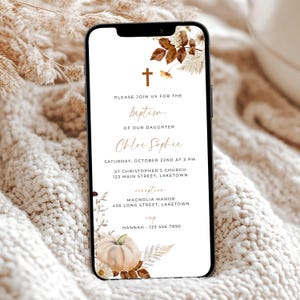 May include: A smartphone displaying a baptism invitation with a gold cross and floral design. The text includes the name "Chloe Sophie", date, time, and venue details. The invitation has a pumpkin illustration and is set against a neutral background.