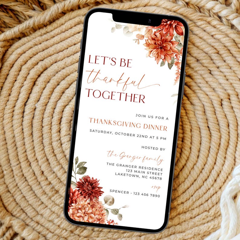 K&ouml;nnte beinhalten: Ein Smartphone zeigt eine Einladung zum Thanksgiving-Dinner. Die Einladung hat florale Akzente in Rot-, Orange- und Braunt&ouml;nen. Der Text lautet "Let's be thankful together" und enth&auml;lt Details zum Abendessen, einschlie&szlig;lich Datum, Uhrzeit und Ort.