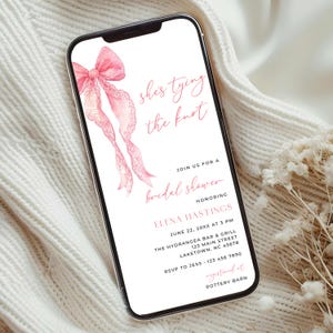 Op de afbeelding: Een smartphone toont een uitnodiging voor een bruidsdouche. De uitnodiging heeft een roze aquarel strik en de tekst "She's tying the knot". Details zijn de datum, tijd, locatie en RSVP-informatie voor de bruidsdouche van Elena Hastings.