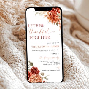 K&ouml;nnte beinhalten: Ein Smartphone zeigt eine Einladung zum Thanksgiving-Dinner. Die Einladung hat orange und rote Blumendesigns mit dem Text "LET'S BE thankful TOGETHER." Details wie Datum, Uhrzeit und Gastgeberinformationen sind enthalten.
