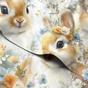 Op de afbeelding: Waterverfillustratie van twee schattige konijntjes met zachte bruine vacht en grote, donkere ogen. Eén konijntje draagt een bloemenkrans van witte, gele en blauwe bloemen. De achtergrond is gevuld met delicate bloemen en bladeren.