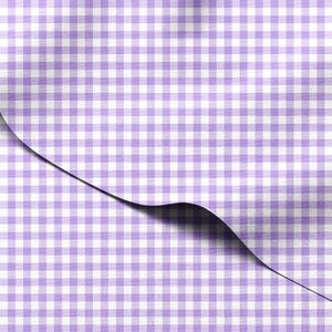 Puede incluir: Primer plano de una tela con un patrón de cuadros vichy en blanco y morado claro. La tela está doblada, revelando una sombra debajo. El patrón es un diseño de cuadros clásico a pequeña escala, adecuado para diversas aplicaciones textiles.